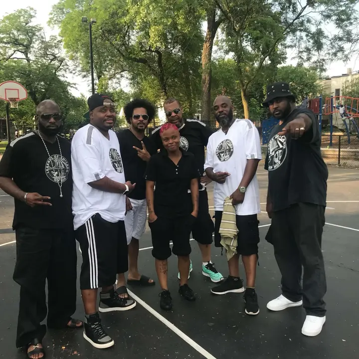 A group of men posing together on a basketball court at the 2018 Hip Hop Camp Out.