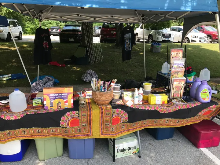 A vendor table covered in an African print cloth, with goods for sale.